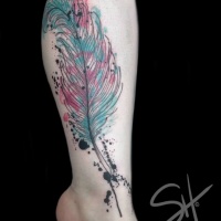 Watercolor style colored leg tattoo of feather and ink