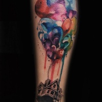 Watercolor style colored leg tattoo of flying balloons with house