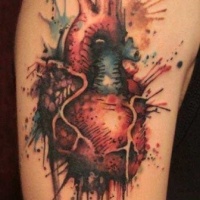 Watercolor style colored shoulder tattoo of human heart