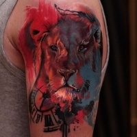 Watercolor style colored shoulder tattoo of lion head with clock