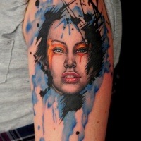 Watercolor style colored shoulder tattoo of woman face with makeup