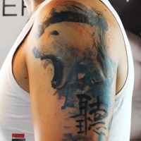 Watercolor style colored shoulder tattoo of big white bear with lettering
