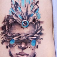 Watercolor style colored tattoo of human face with chain and feather