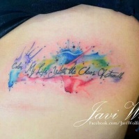 Watercolor style colored thigh tattoo of small lettering