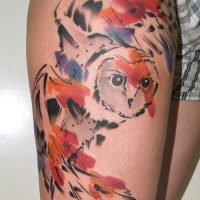 Watercolor style colored thigh tattoo of flying owl