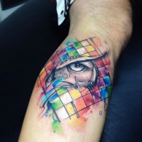 Watercolor style impressive looking leg tattoo of owl eye with geometrical figures