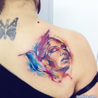 Watercolor style medium size colored shoulder tattoo of woman portrait with hummingbird
