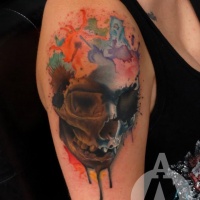 Watercolor style typical looking human skull tattoo on shoulder