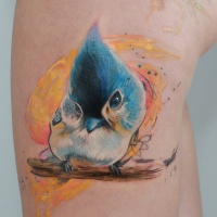 Tatuaggio colorato sulla gamba l'uccello sul bastoncino