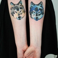 Tatuajes en los antebrazos, lobos estilizados de acuarelas