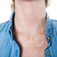 farfalla inchiostro bianco tatuaggio sul collo