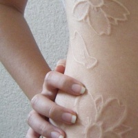 fiori inchiostro bianco tatuaggio sulle costolette