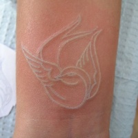 Weiße Tinte kleiner Vogel Tattoo am Handgelenk