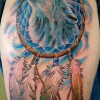 Tatuaje en el brazo, cabeza de lobo y  atrapasueños