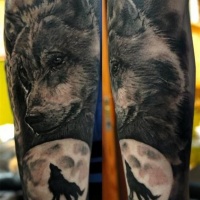 testa di lupo con silhouette di lupo avambraccio tatuaggio