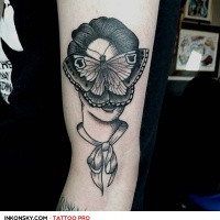 Portrait der Frau mit Schmetterling auf Gesicht schwarzes und weißes Bizeps Tattoo im surrealistischen Stil