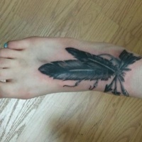 Women arrow tattoo and feathers on foot