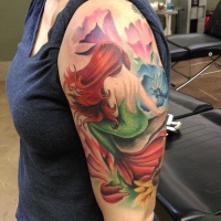Tatuaje en el brazo, sirena grácil entre flores diferentes
