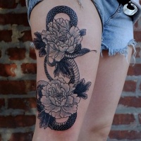 Wonderful combined black and white snake with flowers tattoo on thigh