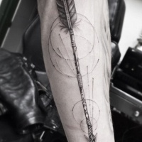 Tatuaje en el antebrazo, flecha apuntanda hacia abajo