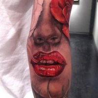Wonderful half woman's face with red lips and rose tattoo sleeve on forearm