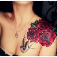 bellissima dipinta grande rose con rondine tatuaggio su petto e spalla
