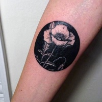 Tatuaje en el antebrazo, flor blanca en un círculo negro
