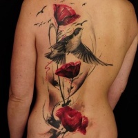 Tatuaje en la espalda, ave con ramo de flores