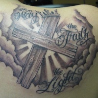 Tatuaje en el hombro,
cruz de madera y cielos
