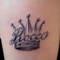 Das Wort Rocco und hübsche Krone Tattoo