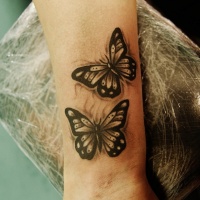 Tatuaje en la muñeca, mariposas de colores megro y blanco