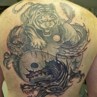Tatuaje en la espalda, yin yang grande, tigre y dragón que 
luchan