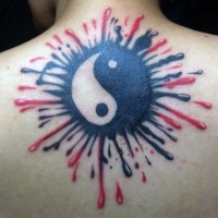 Yin Yang symbol tattoo on upper back with black and red paint splashes