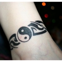 Tatuaggio intorno del polso il disegno nero in stile Yin-Yang