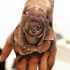 Tatuaje en la mano,  rosa de papel con gotas de agua