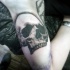 Tatuaje en el brazo, cráneo humano tremendo