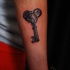 Tatuaje  de llave antigua con ornamento en el antebrazo