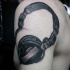 Tatuaje en el brazo,
 auriculares grandes negras 3D