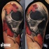 3D style colored shoulder tattoo of human skull with maple leaves
