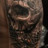 Estilo 3D detallado del brazo del tatuaje del cráneo humano con arañas