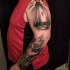 Tatuaje en el hombro,
faro oscuro en el mar y barco pirata impresionante