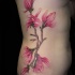 eccezionale fiore brillante di magnolia colore rosa con scrittura tatuaggio su lato