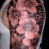 Tatuaje en el brazo, flores grandes con hojas, tinta negra