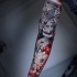 Awesome realistic tiger and flowers tattoo on arm