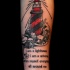 Tatuaje en el antebrazo,
faro de color rojo y negro y texto