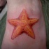 Tatuaje en el pie, estrella de mar preciosa de color naranja