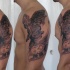 Grand ange et horloge tatouage sur le bras