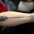 Tatuaje en el antebrazo, flecha vieja desgastada