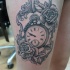 Tatuaje en el muslo,  reloj en el espejo decorado con flores