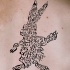 Tatuaje  de liebre formado de letras, tinta negra